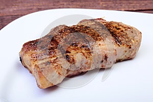 Grilled pork chop on plate on wooden board