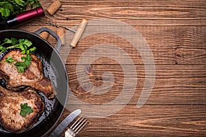 Grilled pork chop with spices in a frying pan.