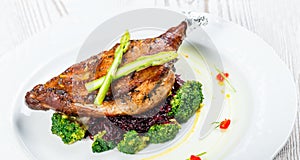 Grilled pork chop steak on the bone with asparagus and broccoli on light wooden background close up. Hot Meat Dishes.