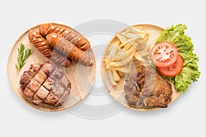 Grilled pork chop steak, sausage with french fries isolated on w