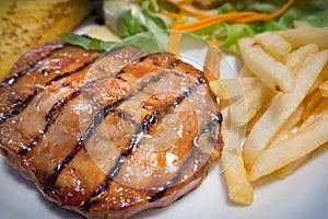 The grilled pork chops steak on white plate close up image