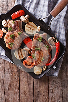 Grilled pork with mushrooms in a pan grill. vertical top view