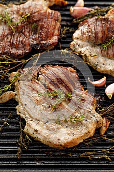 Grilled pork neck with herbs and garlic on a cast iron grill plate