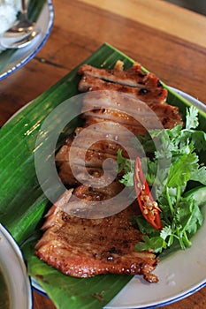 Grilled pork neck with spicy sauce, soft and chewy, very delicious taste on wooden table.