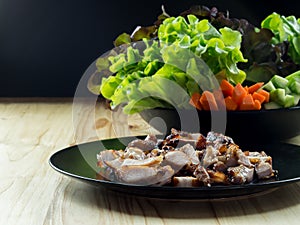 Grilled pork in a plate and Green leafy vegetables.