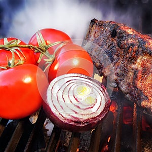 Grilled pork ribs on the flaming BBQ grill.