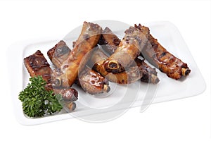 Grilled pork ribs on a plate isolated on white