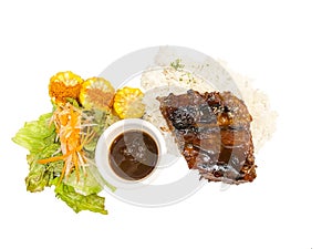 Grilled pork ribs with rice and fresh vegetables and corn on a white background