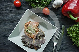 Grilled pork ribs steaks with spices and herbs. Decorated with fresh Bulgarian pepper, cherry tomatoes, lettuce, curly parsley.