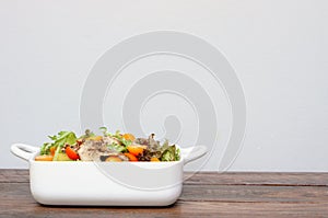 Grilled pork salad with lettuce and tomato on wooden table