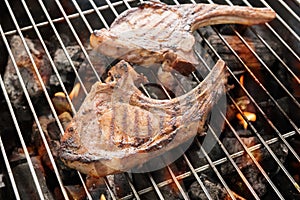 Grilled pork steaks over flames on the grill