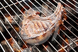 Grilled pork steaks over flames on the grill