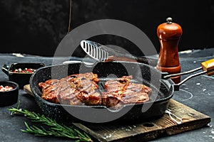 Grilled pork steaks, pork neck with herbs and spices on the grill pan, Restaurant menu, dieting, cookbook recipe place for text