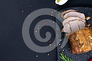 Grilled pork steaks and rosemary with hot paper and sauce on black stone background