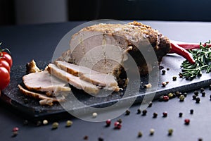 Grilled pork steaks and rosemary with hot paper and sauce on black stone background