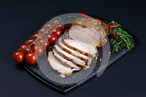 Grilled pork steaks and rosemary with hot paper and sauce on black stone background