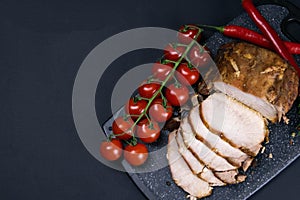 Grilled pork steaks and rosemary with hot paper and sauce on black stone background