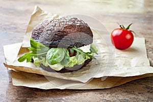 Grilled portobello bun mushroom burger. Vegan, gluten free, grain free, healthy veggies hamburger with guacamole, fresh vegetables