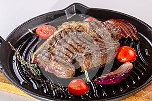 Grilled premium rib eye beef steak in the pan, cooking steak in the kitchen on a dark background, top view