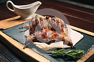 Grilled quails on wooden plate in a restaurant