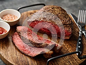 Grilled ramp cap steak on a cutting board. Barbecue Grilled rump cap or brazilian picanha beef meat steak in a wooden tray