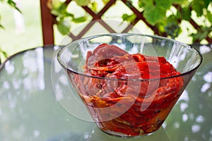 Grilled red bell peppers with salt and olive oil, in a glass bowl