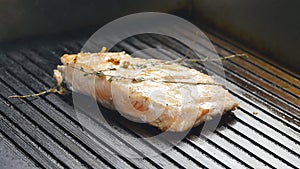 Grilled red fish steak salmon on the grill in slow motion