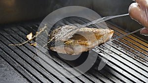Grilled red fish steak salmon on the grill in slow motion