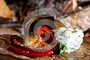 grilled red peppers with cottage cheese and herbs on a wooden table