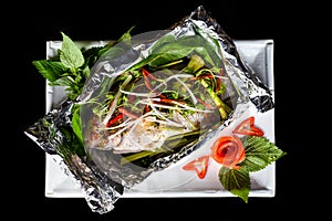 Grilled red perch with vegetables greens and white rice isolated on black background top view