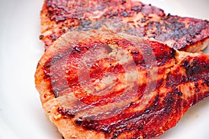 Grilled red tuna steak with pepper macro on a white plate