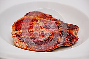 Grilled red tuna steak with pepper macro on a white plate