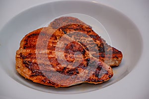 Grilled red tuna steak with pepper macro on a white plate