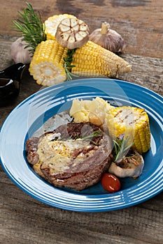 Grilled rib eye steak with vegetables and potato puree in butter sauce