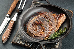 Grilled ribeye beef steak with red wine, herbs and spices. Marbled beef steak medium rare on a black background with