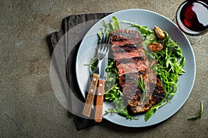 Grilled ribeye beef steak with red wine, herbs and spices. Top view with copy space for your text. Flat lay