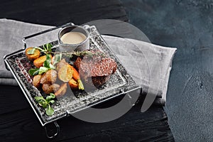 Grilled ribeye steak on stone grill on a dark background