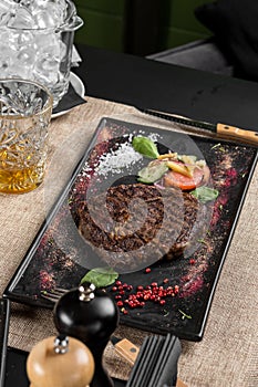 Grilled Ribeye Steak with vegetable salad on stone board on the table at restaurant
