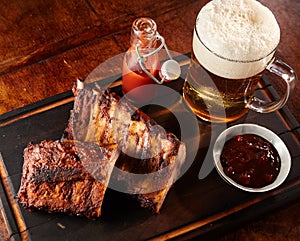 Grilled ribs with a cold beer with frothy head photo