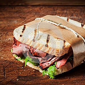 Grilled roast beef sandwich in a takeaway wrapper