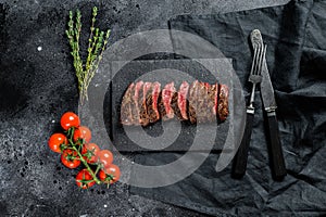Grilled roasting rare sliced skirt, machete steak. Marble meat beef. Black background. Top view