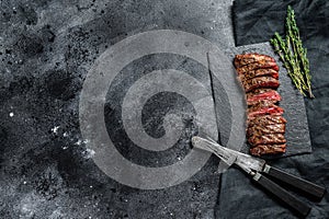 Grilled roasts rare skirt, machete steak. Marble meat beef. Black background. Top view. Copy space
