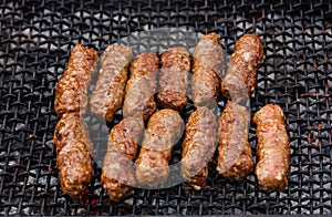 Grilled Romanian meat rolls on barbecue grid - mititei, mici