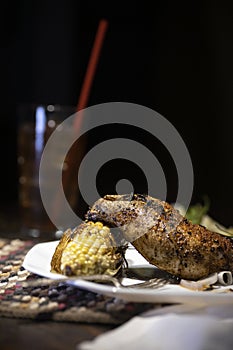 Grilled rosemary chicken dinner with corn and salad.