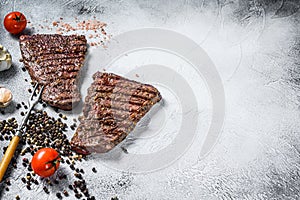 Grilled rump steak with spices. BBQ beef. Gray background. Top view. Copy space