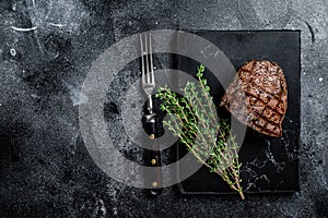 Grilled Rump steak with spices, cooked beef meat. Black background. Top view. Copy space