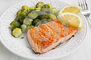 Grilled salmon with brussels sprouts garnish and lemon