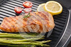 Grilled salmon cooked BBQ on a pan on wooden background photo