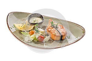 Grilled salmon fillet with lemon and fresh salad on grey plate isolated on white background