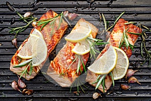 Grilled salmon fillets sprinkled with fresh herbs and lemon juice on a grill plate